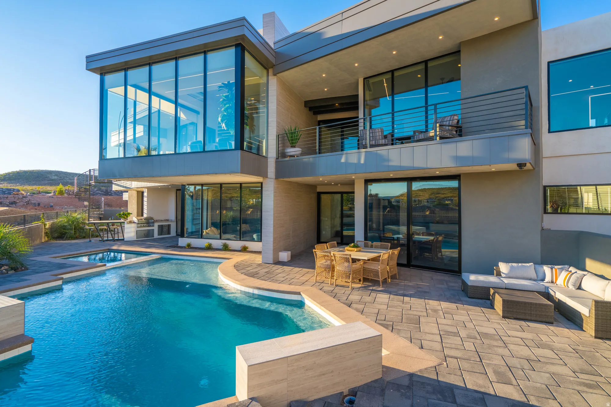 Rear view of house with outdoor lounge area, a patio, a pool with connected hot tub, outdoor dining area, and a balcony