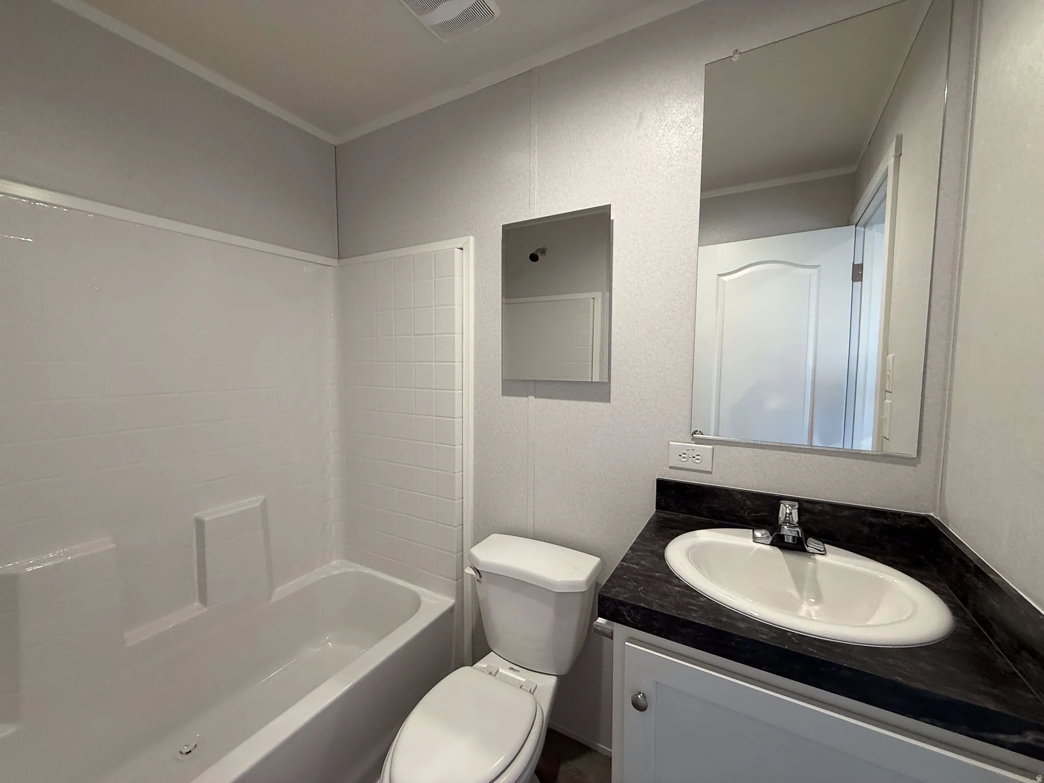 Bathroom featuring vanity, shower / tub combination, and crown molding