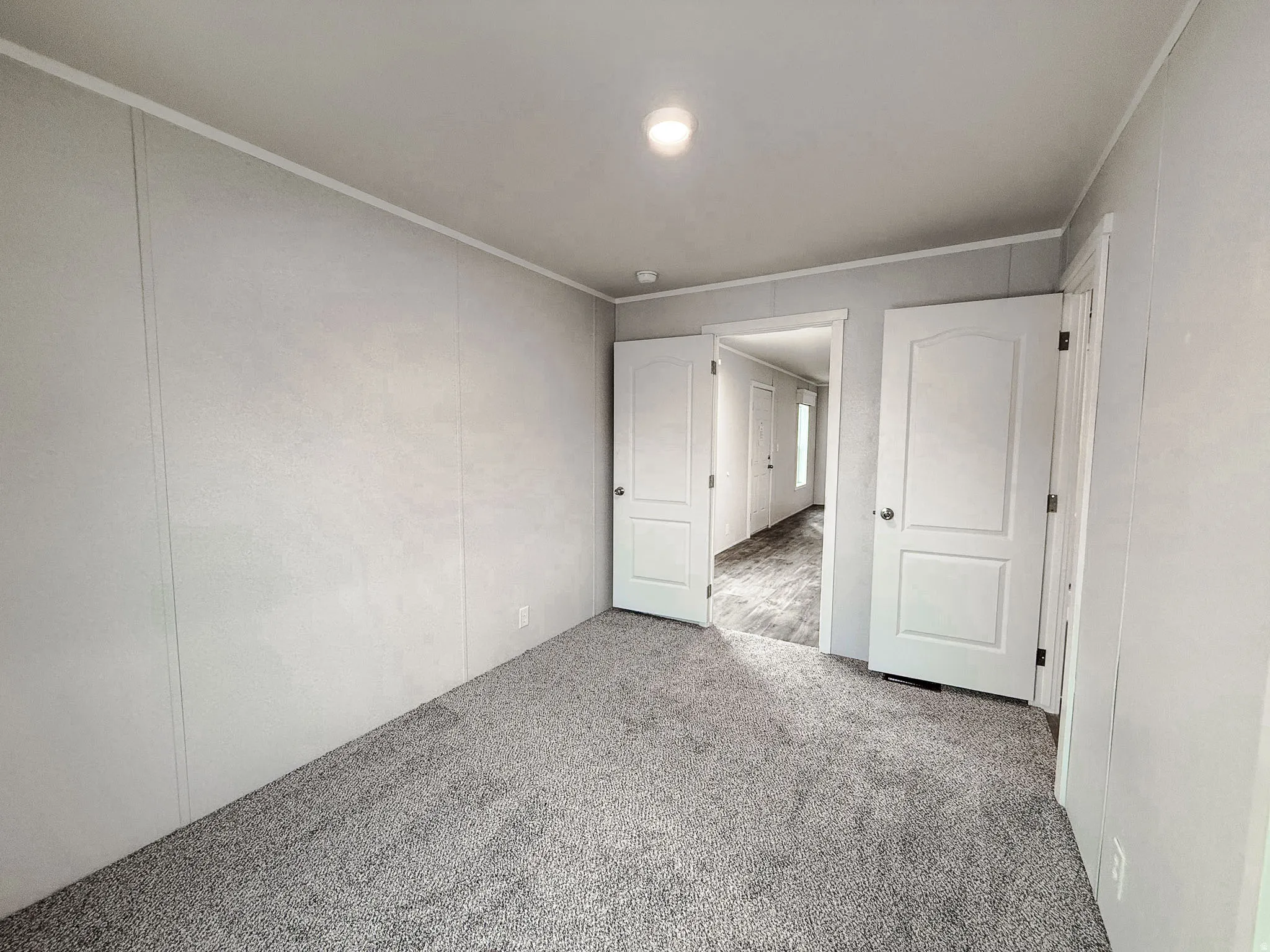 Carpeted empty room with ornamental molding and a decorative wall