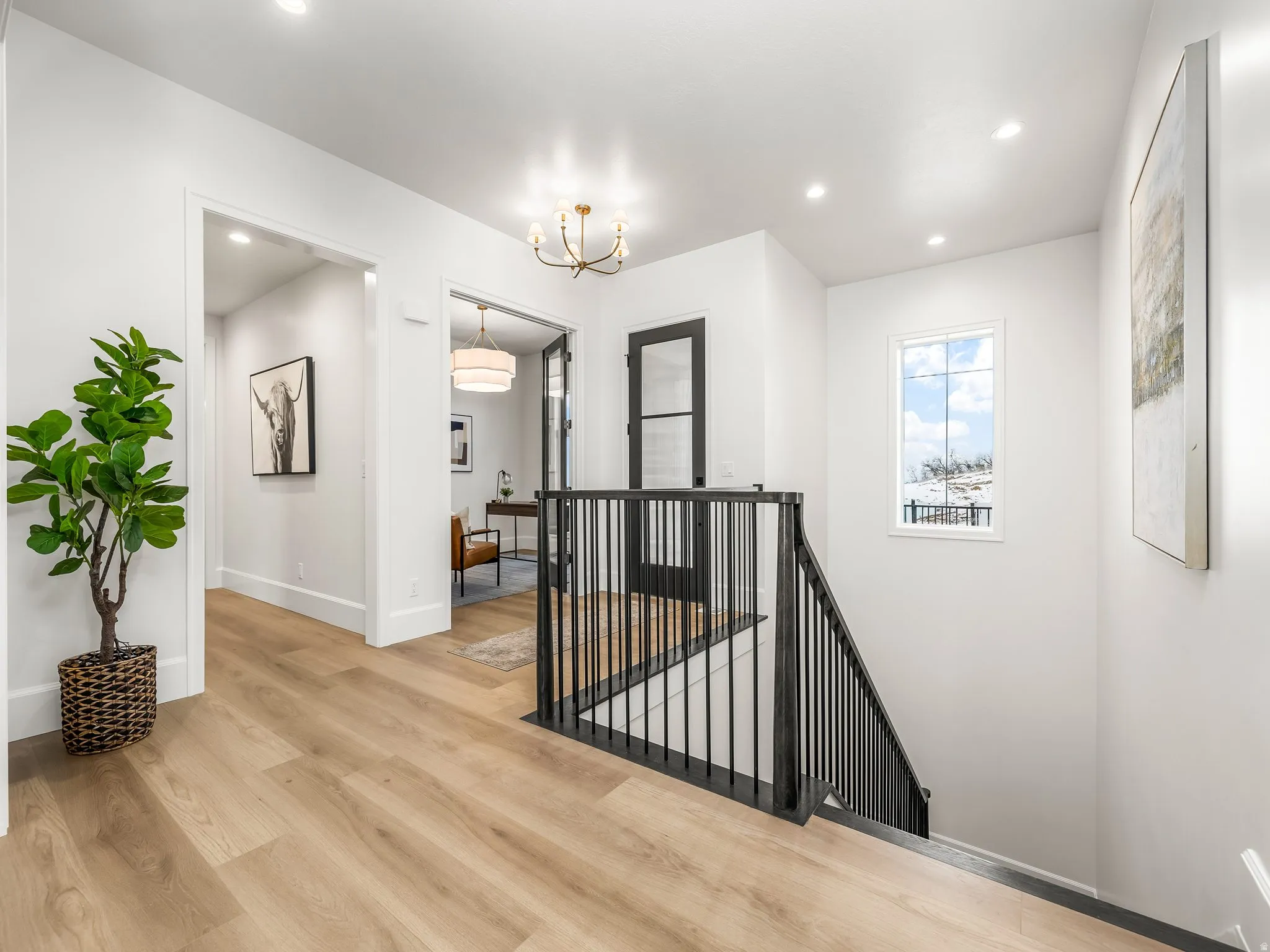 Hallway featuring an upstairs landing, light wood-style floors, a chandelier, and recessed lighting