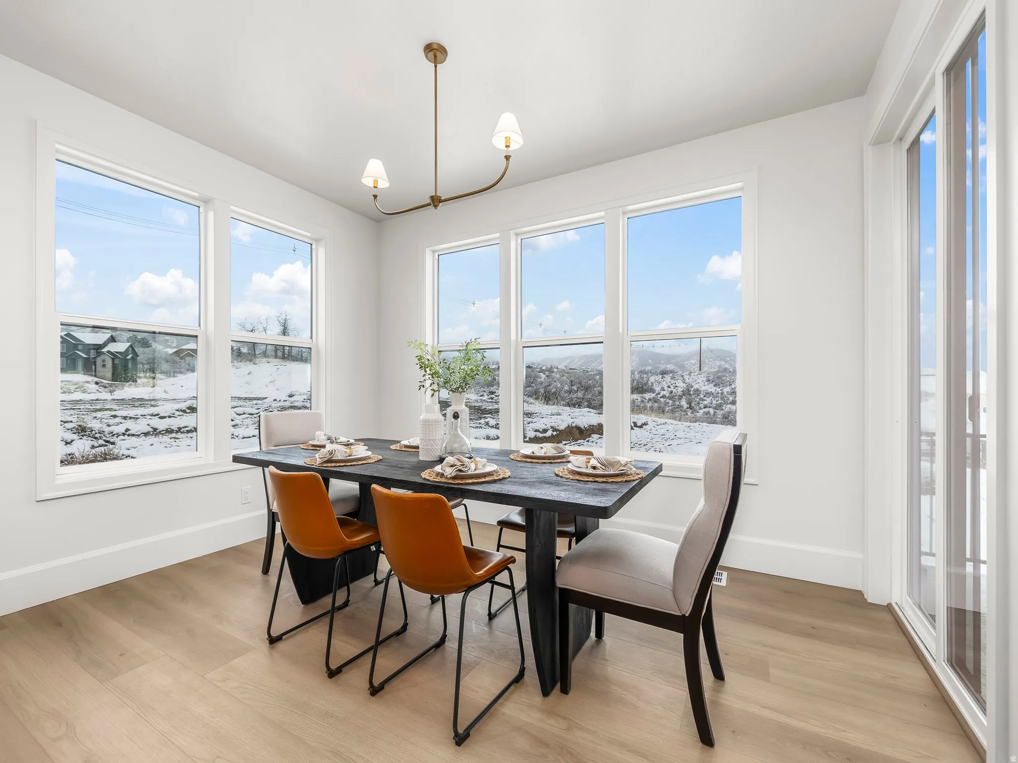 Dining space with light wood finished floors and a chandelier