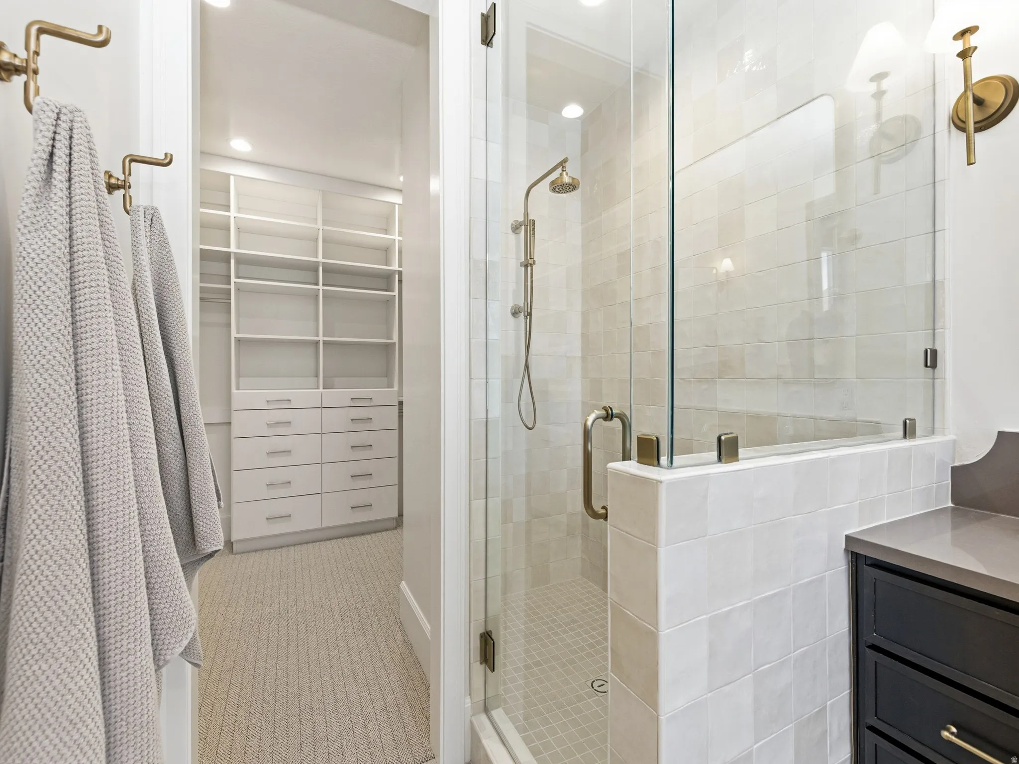 Bathroom featuring a stall shower, a spacious closet, and vanity