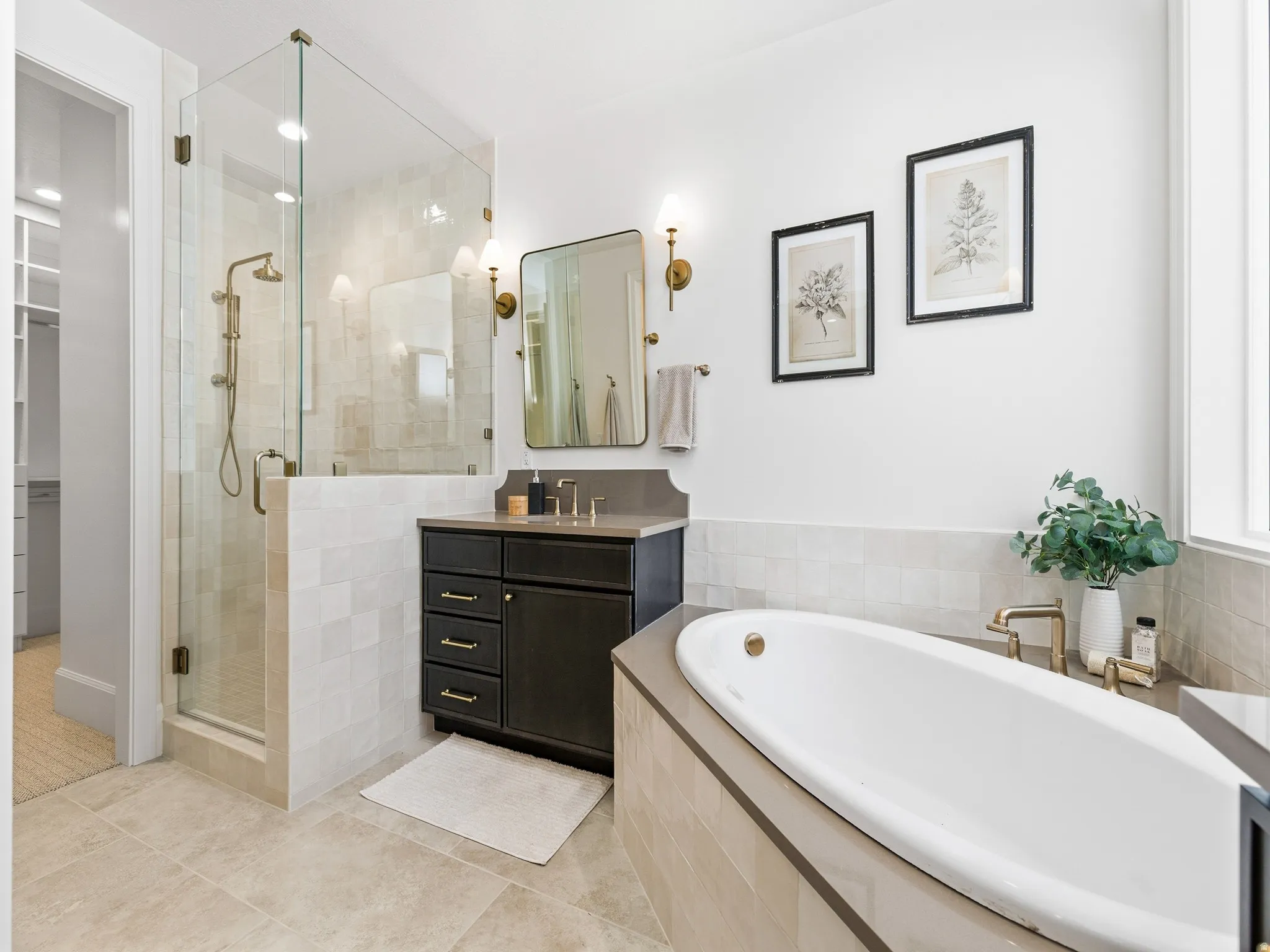 Full bath featuring a garden tub, vanity, a stall shower, and a walk in closet