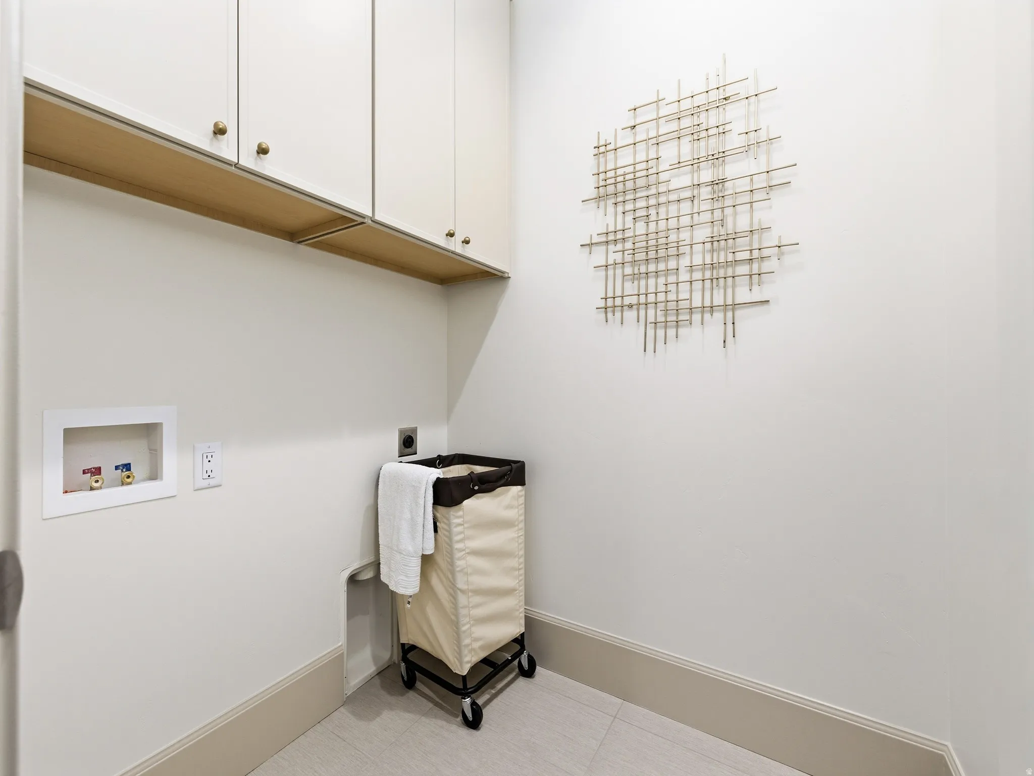 Laundry room with hookup for a washing machine, cabinet space, tile patterned floors, and electric dryer hookup