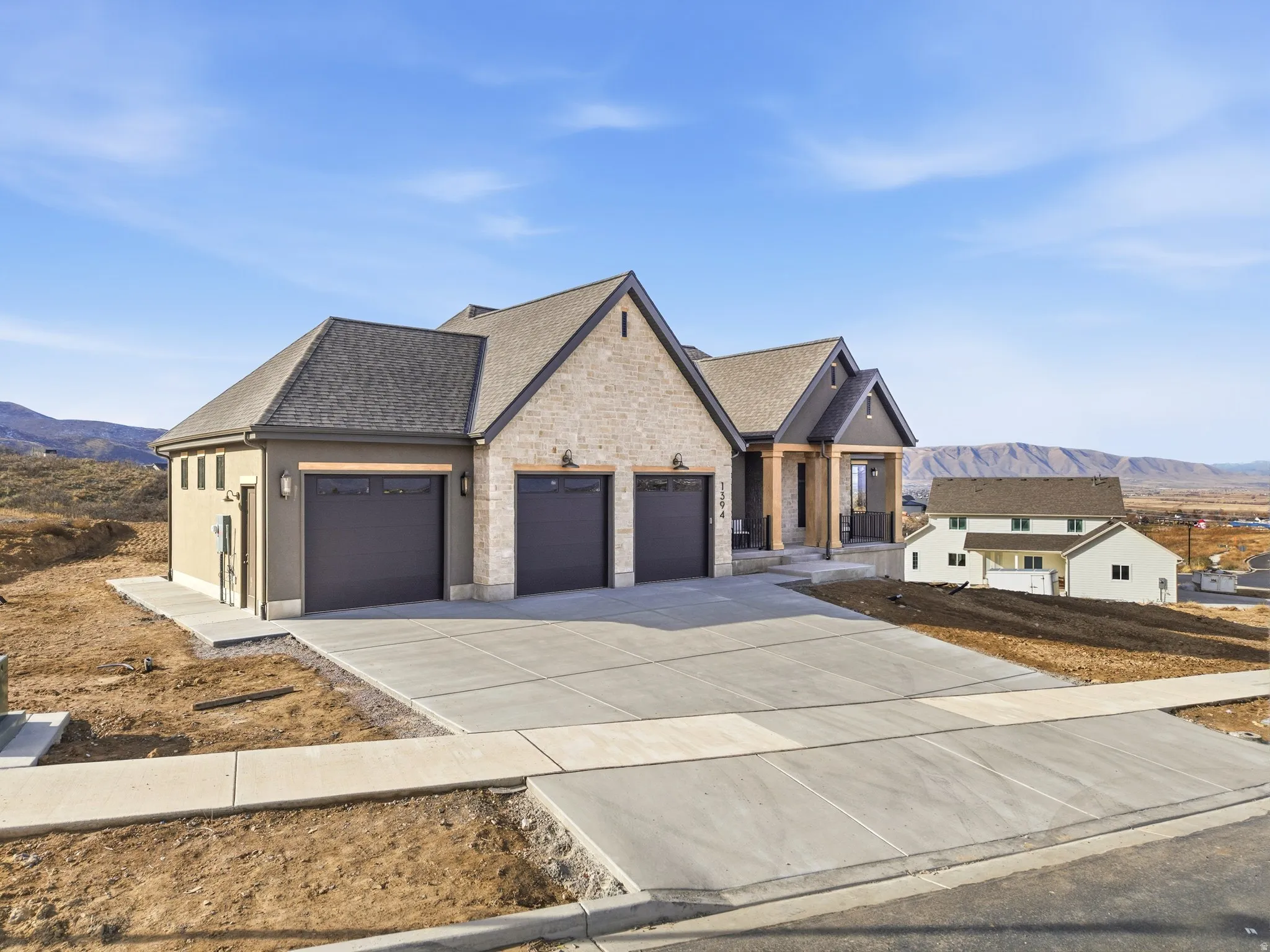 View of front of home with driveway, a mountain view, roof with shingles, and an attached garage