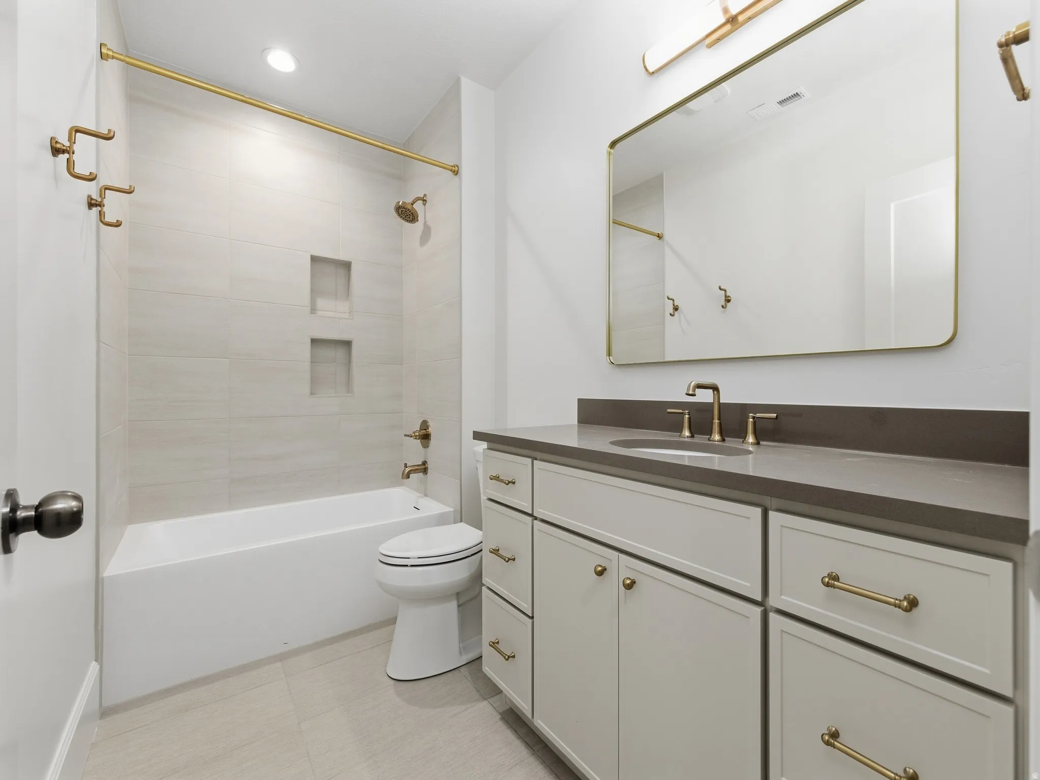 Full bath with  shower combination, vanity, and light tile patterned flooring