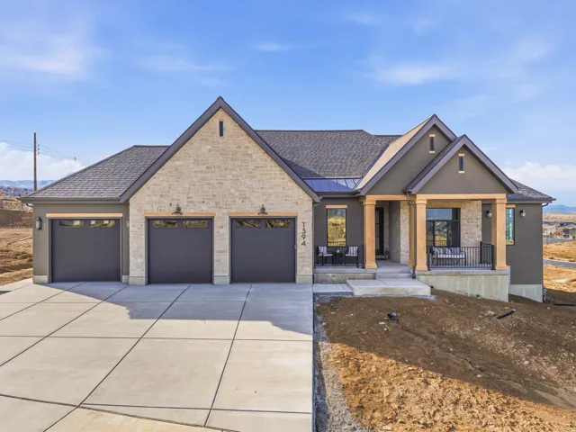 View of front of house with a porch, a shingled roof, concrete driveway, a standing seam roof, and an attached garage