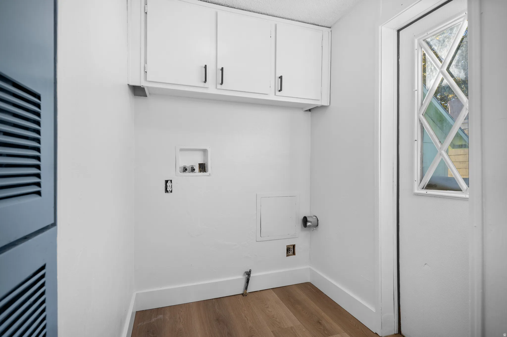 Laundry room with light wood-style floors, washer hookup, a heating unit, cabinet space, and gas dryer hookup