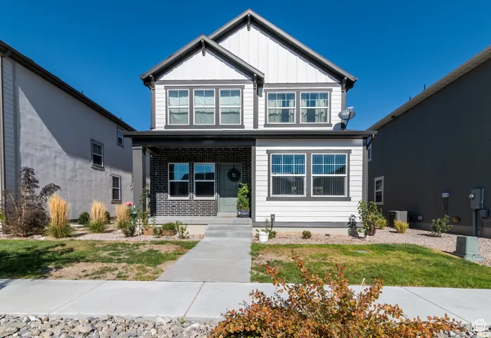 View of front of property featuring a porch, board and batten siding, and a front yard