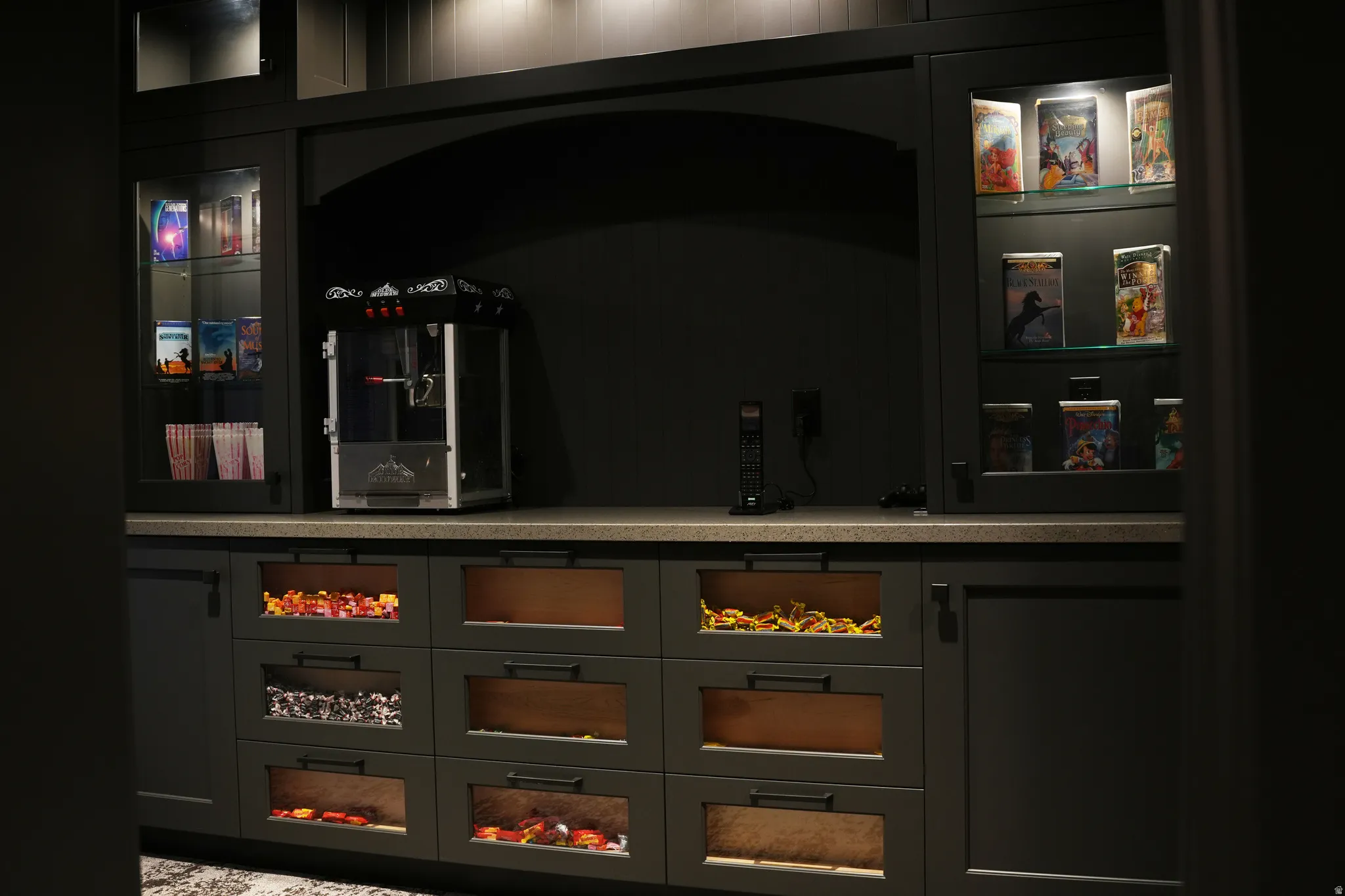 Bar area featuring glass insert cabinets, gray cabinets, and light stone countertops