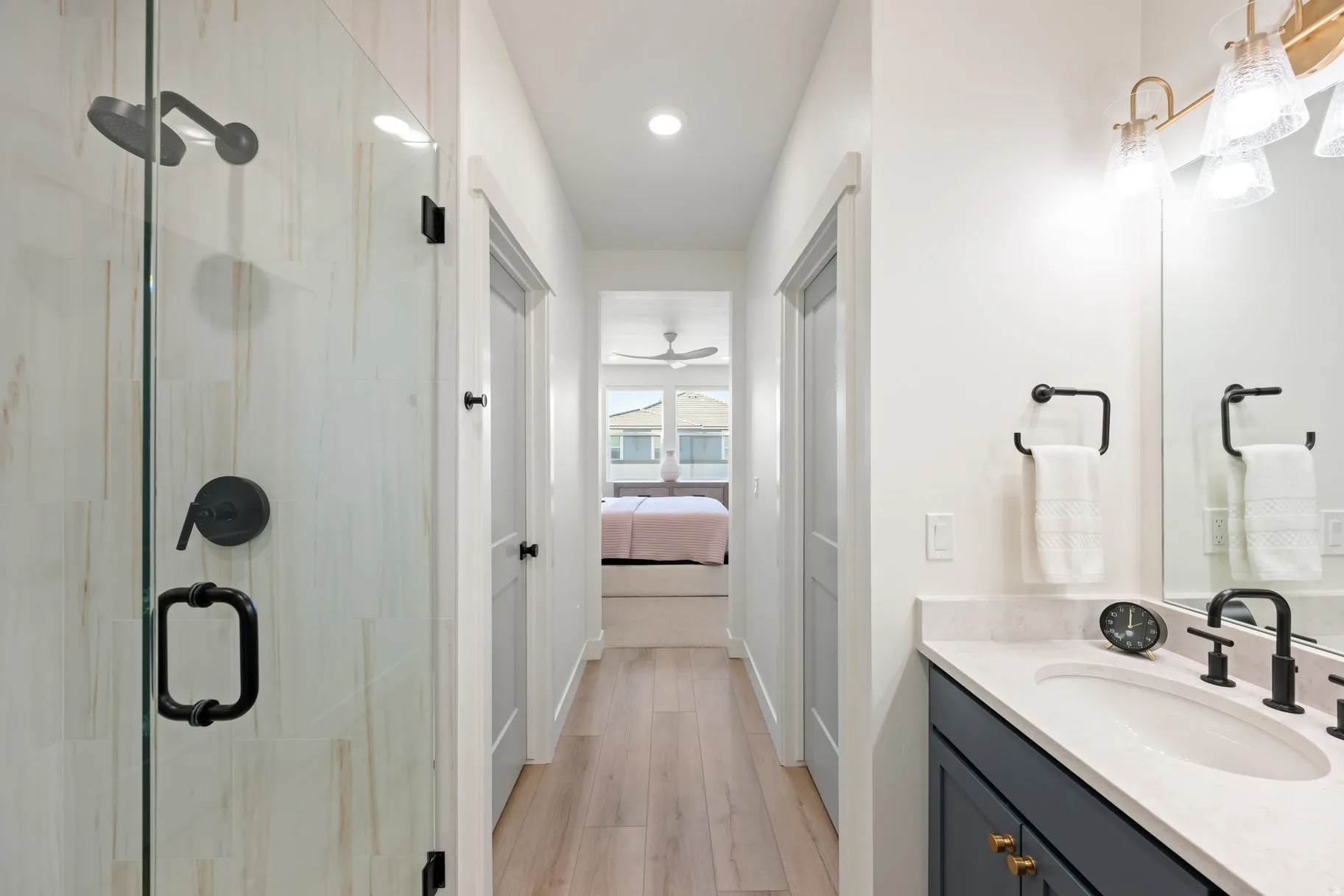 Ensuite bathroom featuring vanity, a stall shower, light wood finished floors, and recessed lighting