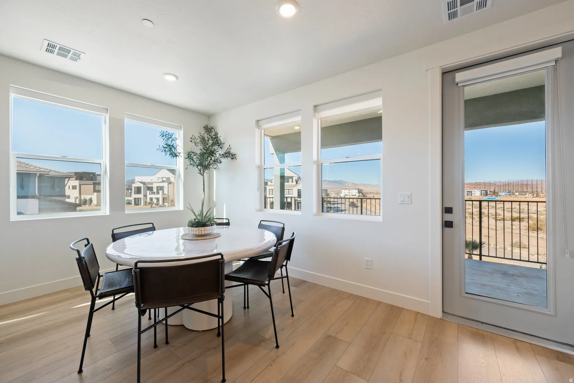 Dining room with light wood-style floors and recessed lighting