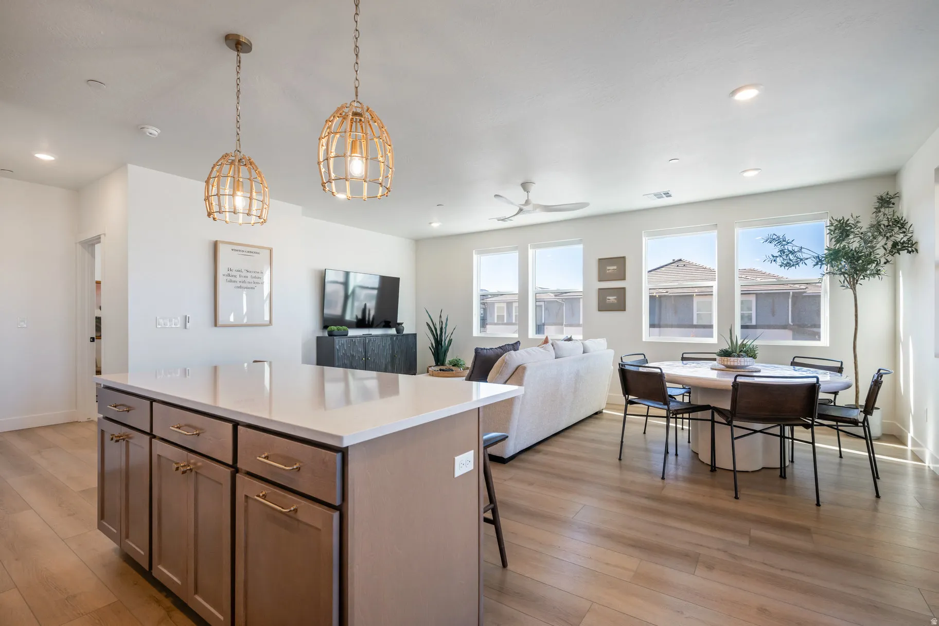Kitchen with a center island, open floor plan, light wood-type flooring, decorative light fixtures, and a breakfast bar