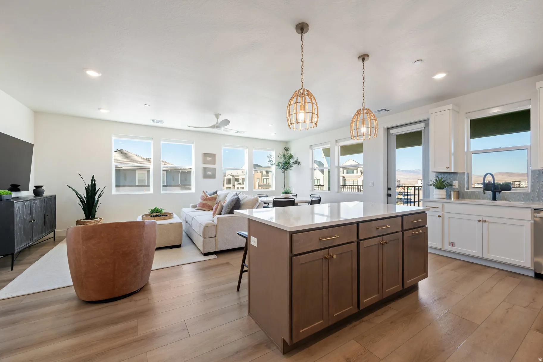 Kitchen featuring open floor plan, a center island, light wood-style floors, a breakfast bar, and two tone cabinets