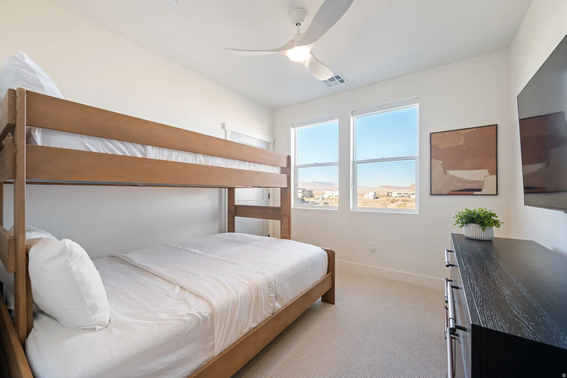 Bedroom with light carpet and a ceiling fan