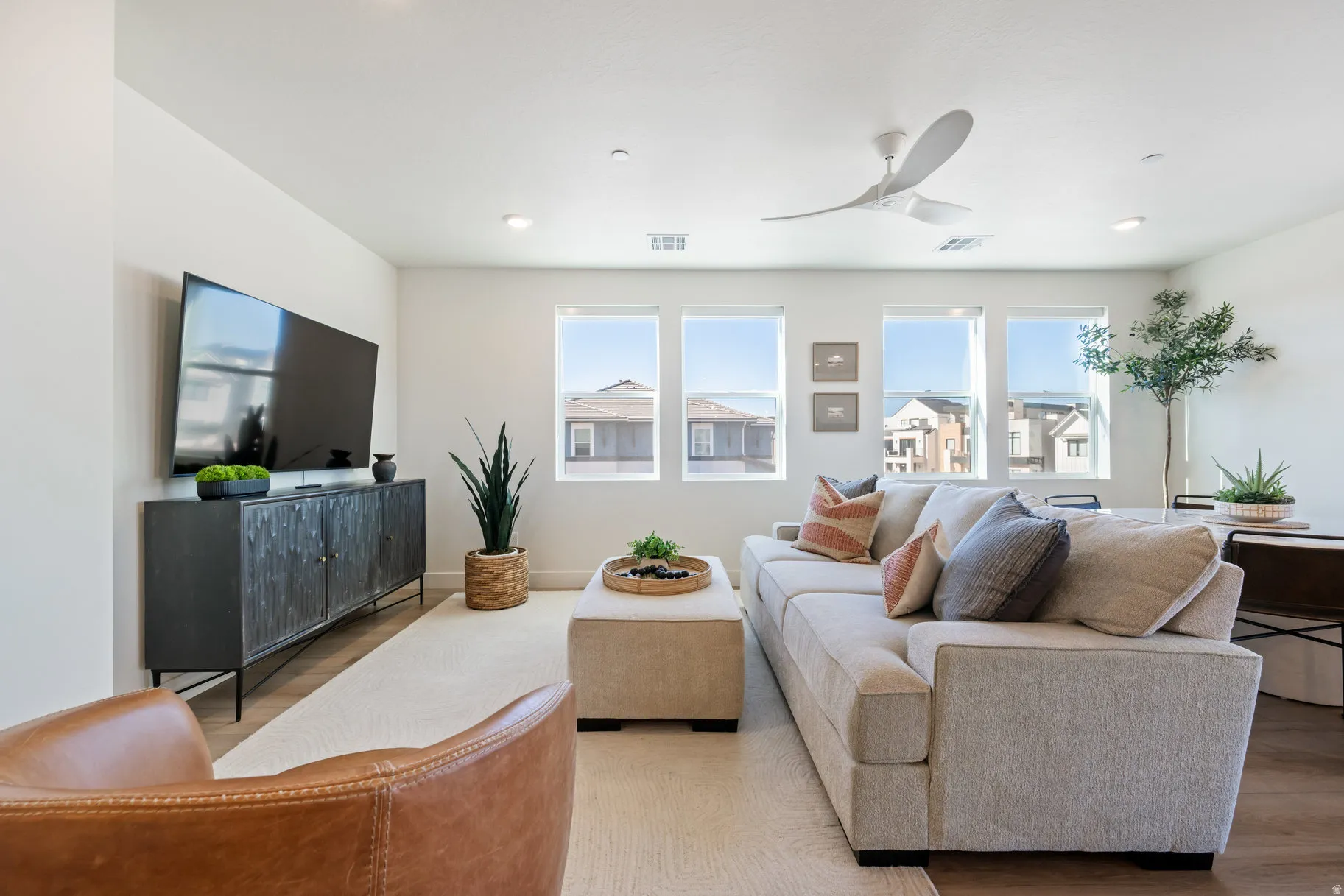 Living area with a ceiling fan, light wood-style floors, and recessed lighting