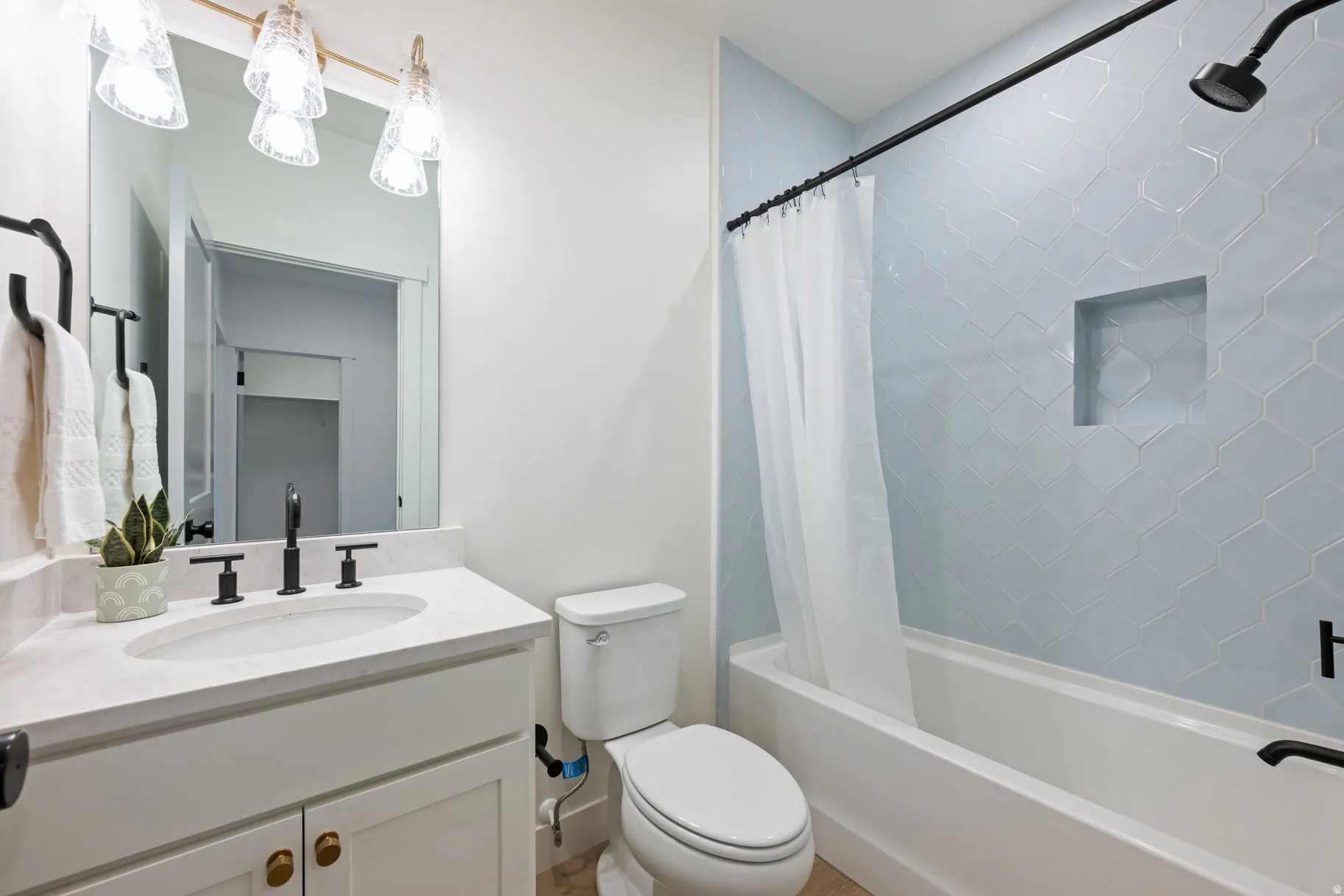 Bathroom featuring vanity and shower / bathtub combination with curtain
