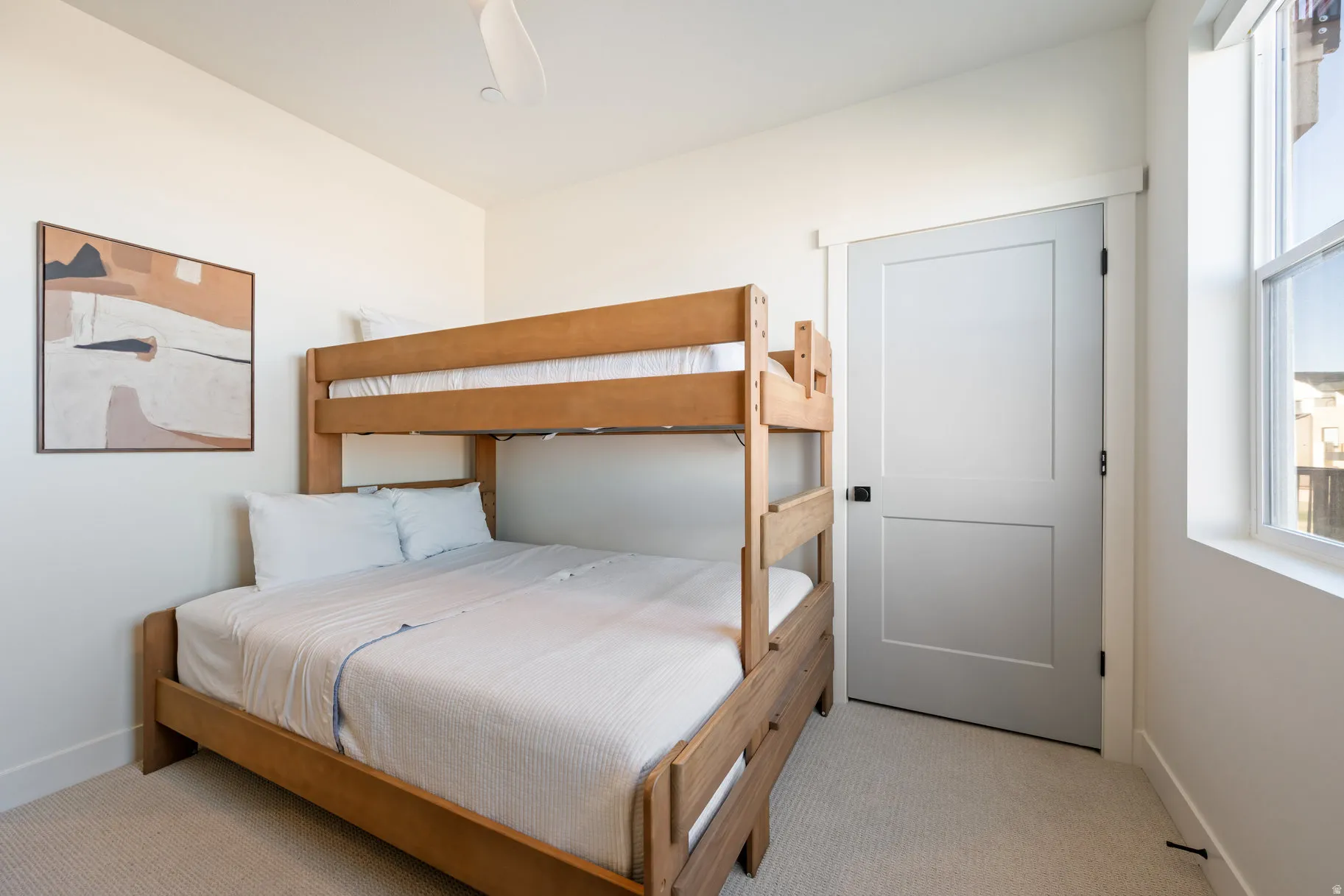 Bedroom with multiple windows, a ceiling fan, and light carpet