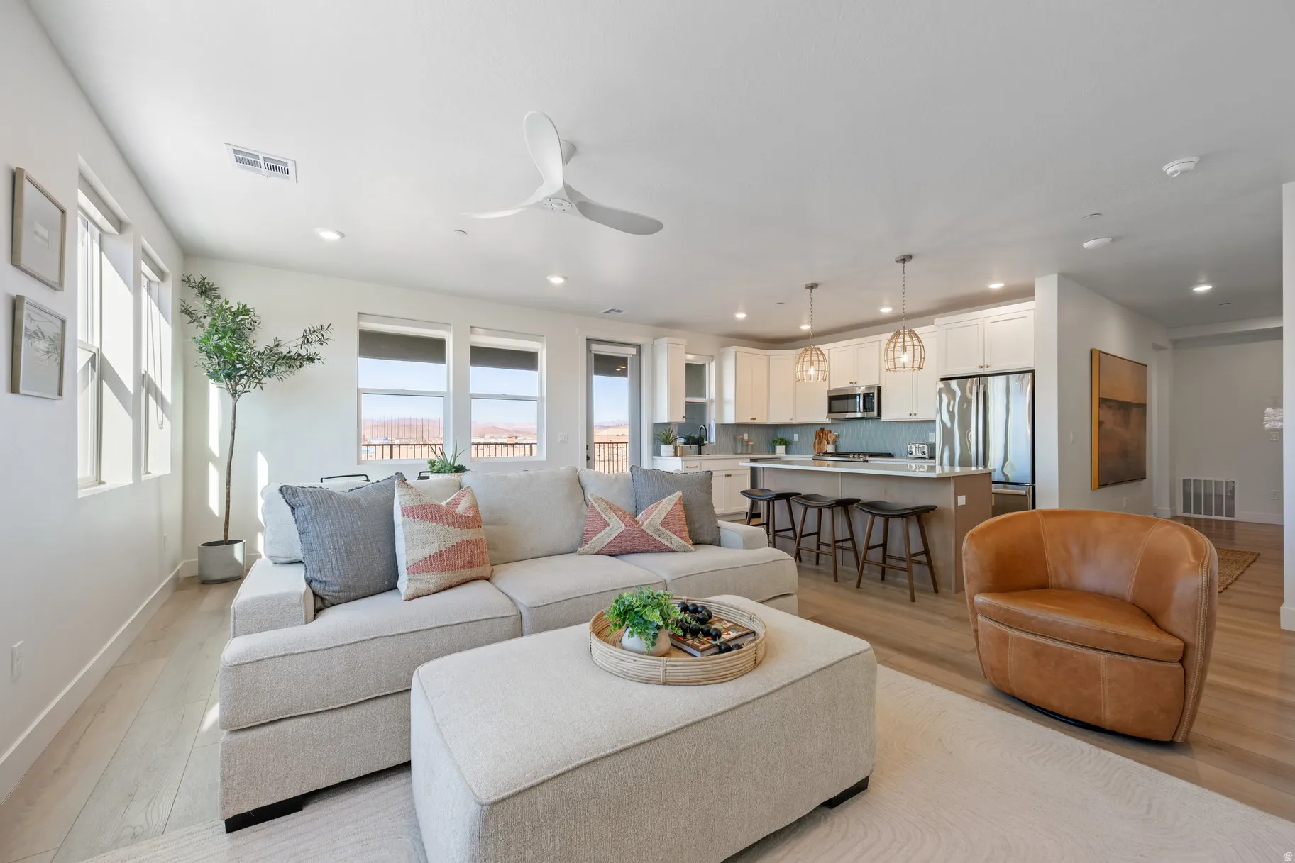 Living area featuring light wood-style floors, a ceiling fan, and recessed lighting