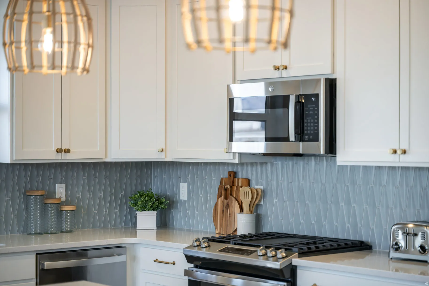 Kitchen featuring white cabinetry, stainless steel appliances, light stone counters, and tasteful backsplash
