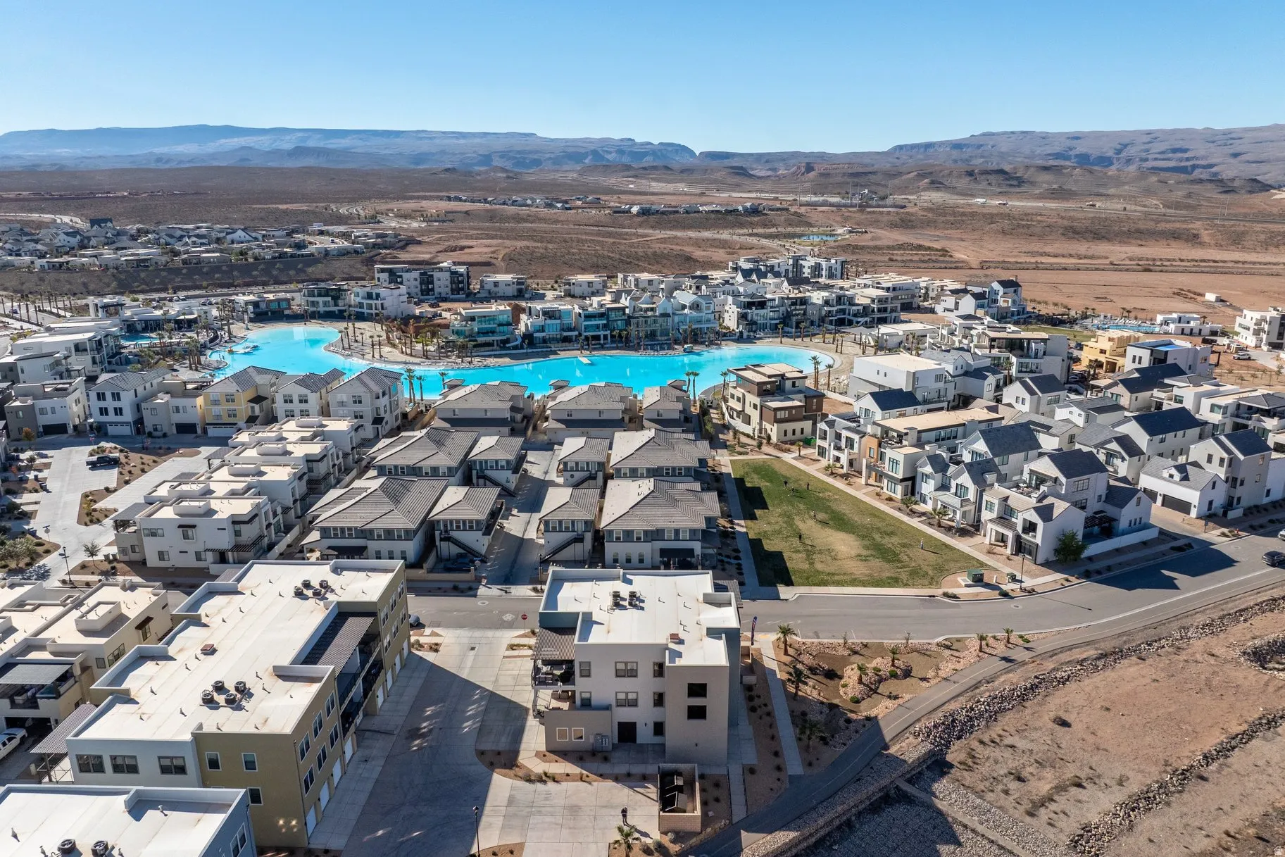 Aerial perspective of suburban area featuring a mountain backdrop and a pool area