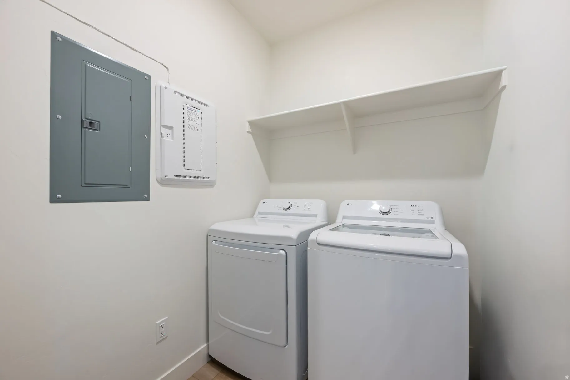 Laundry area with electric panel and washing machine and clothes dryer