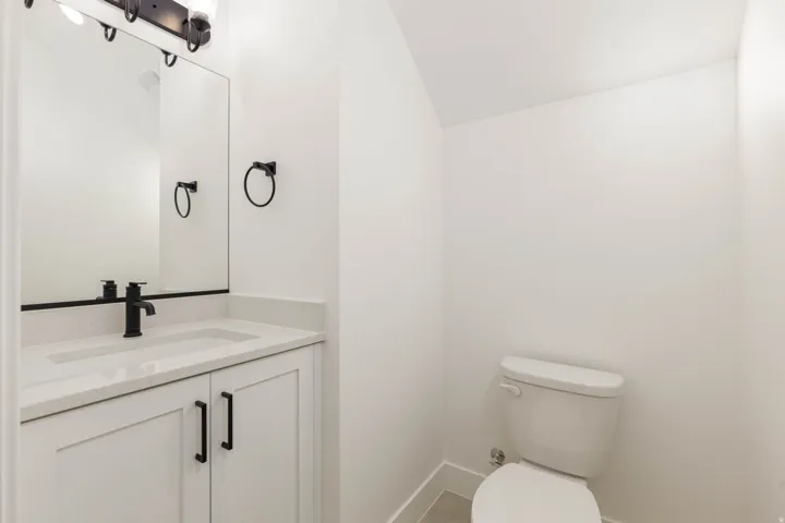 Half bath featuring vanity and vaulted ceiling