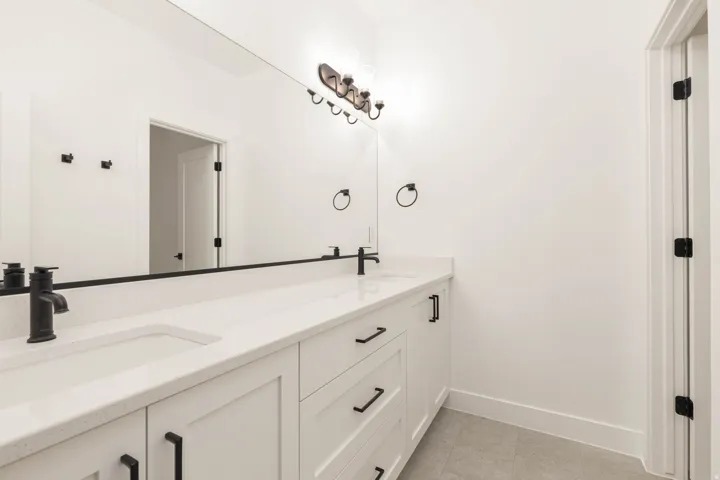 Full bathroom featuring double vanity and light tile patterned floors