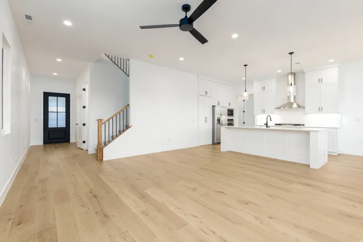 Unfurnished living room with light wood-style floors, stairs, recessed lighting, and ceiling fan