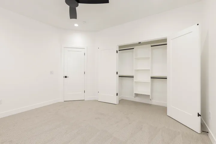 Unfurnished bedroom with light colored carpet, ceiling fan, a closet, and recessed lighting