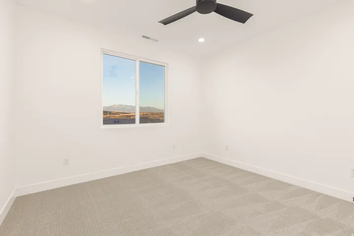 Carpeted empty room with baseboards and recessed lighting