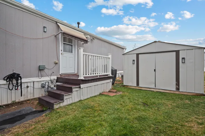 View of green lawn with a storage unit