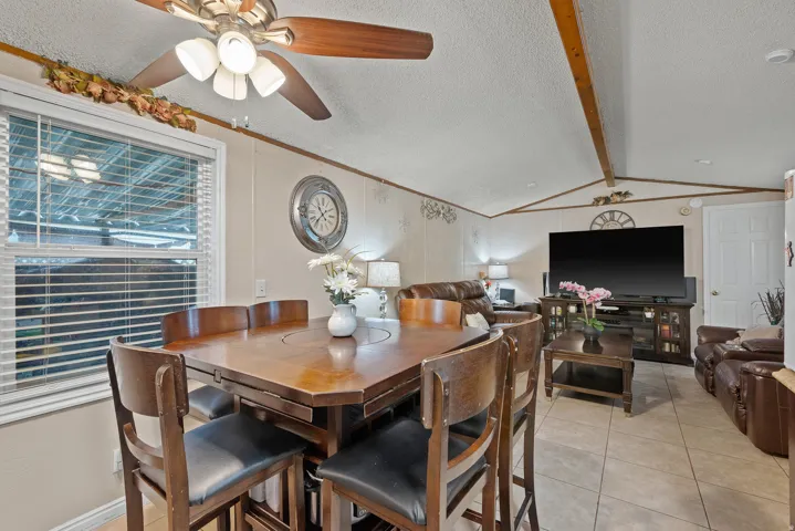 Dining area featuring a textured ceiling, light tile patterned floors, and a ceiling fan