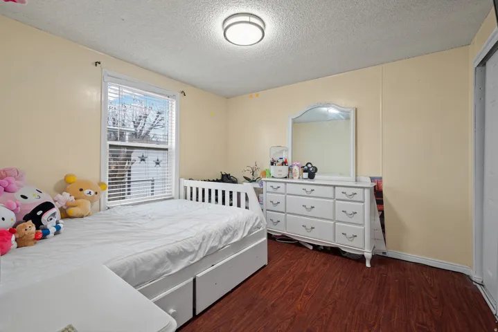 Bedroom featuring dark wood-style flooring and a textured ceiling