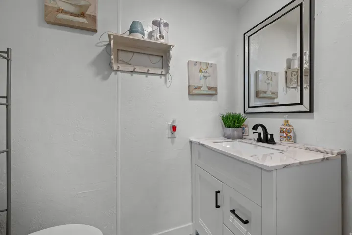 Bathroom with a textured wall and vanity