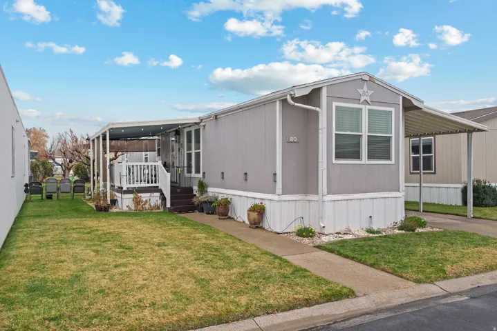 View of home's exterior featuring a yard and a carport