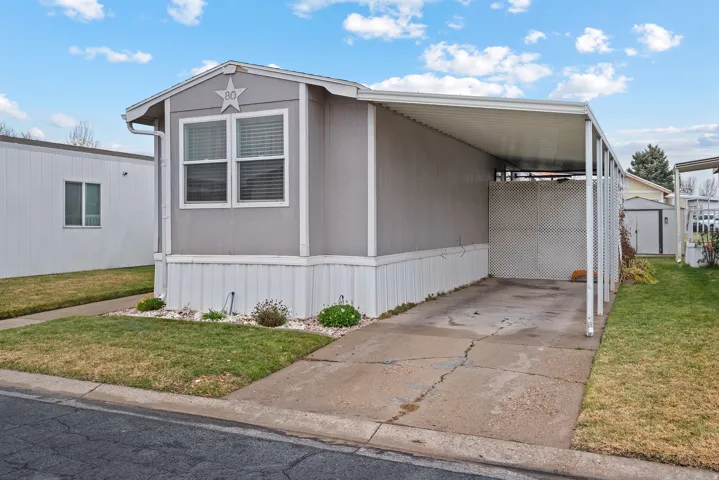 View of front of home featuring a front yard, driveway, and an attached carport