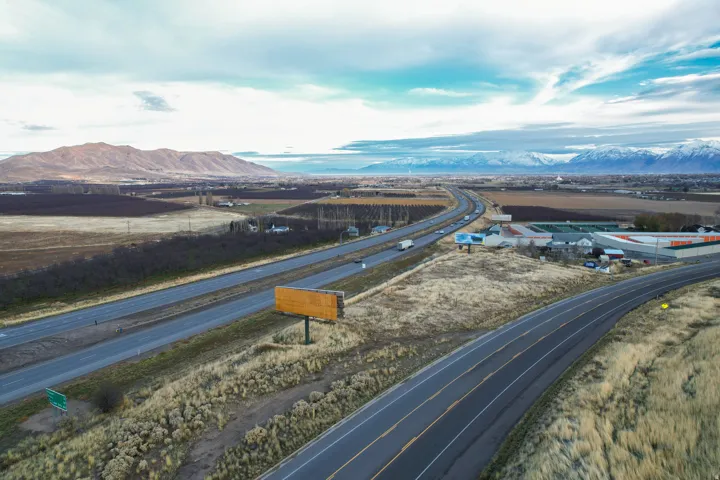 Drone / aerial view of a highway and a mountainous background