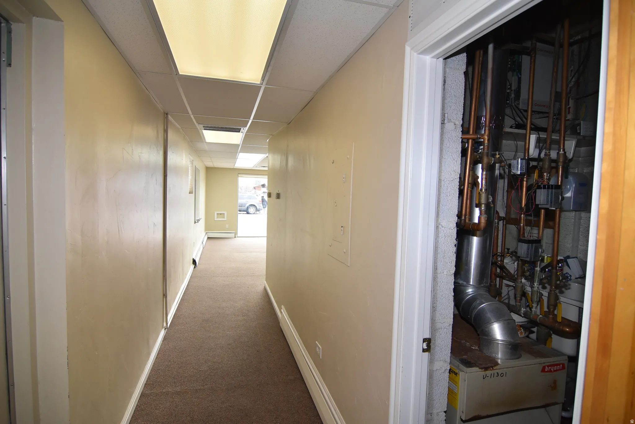 Hallway featuring carpet floors and a drop ceiling