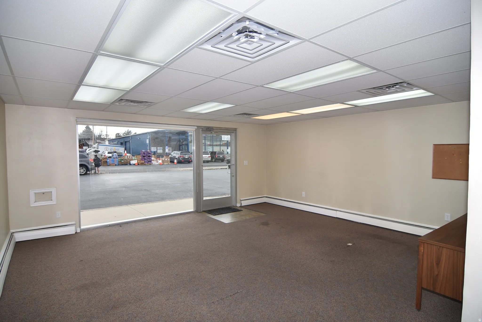 Spare room with a paneled ceiling, carpet floors, and baseboard heating