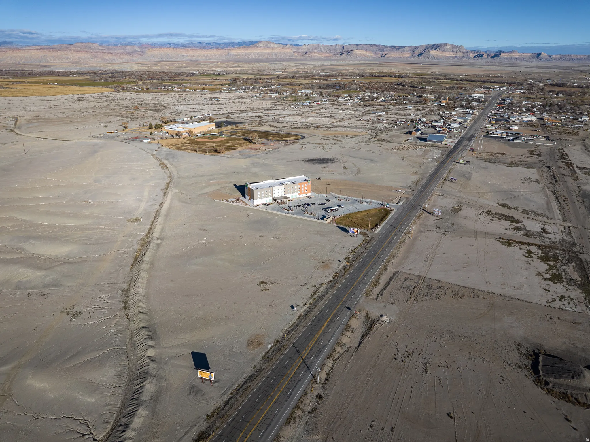 Aerial overview of property's location with a mountainous background and a desert landscape