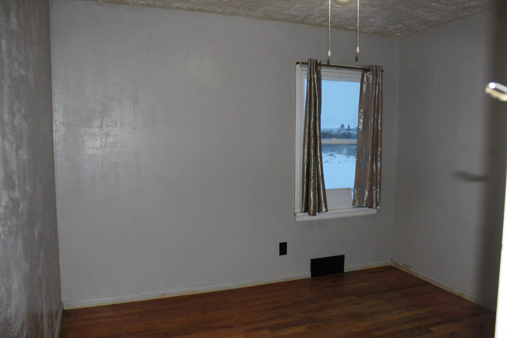 Spare room with dark wood finished floors and baseboards
