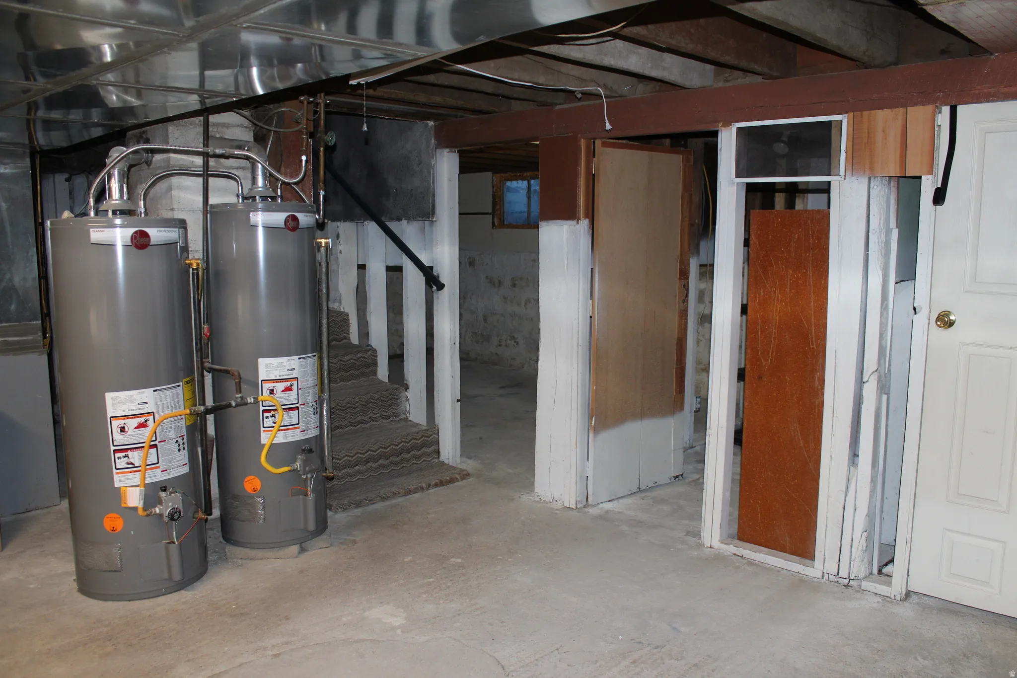 Unfinished basement featuring gas water heater and heating unit