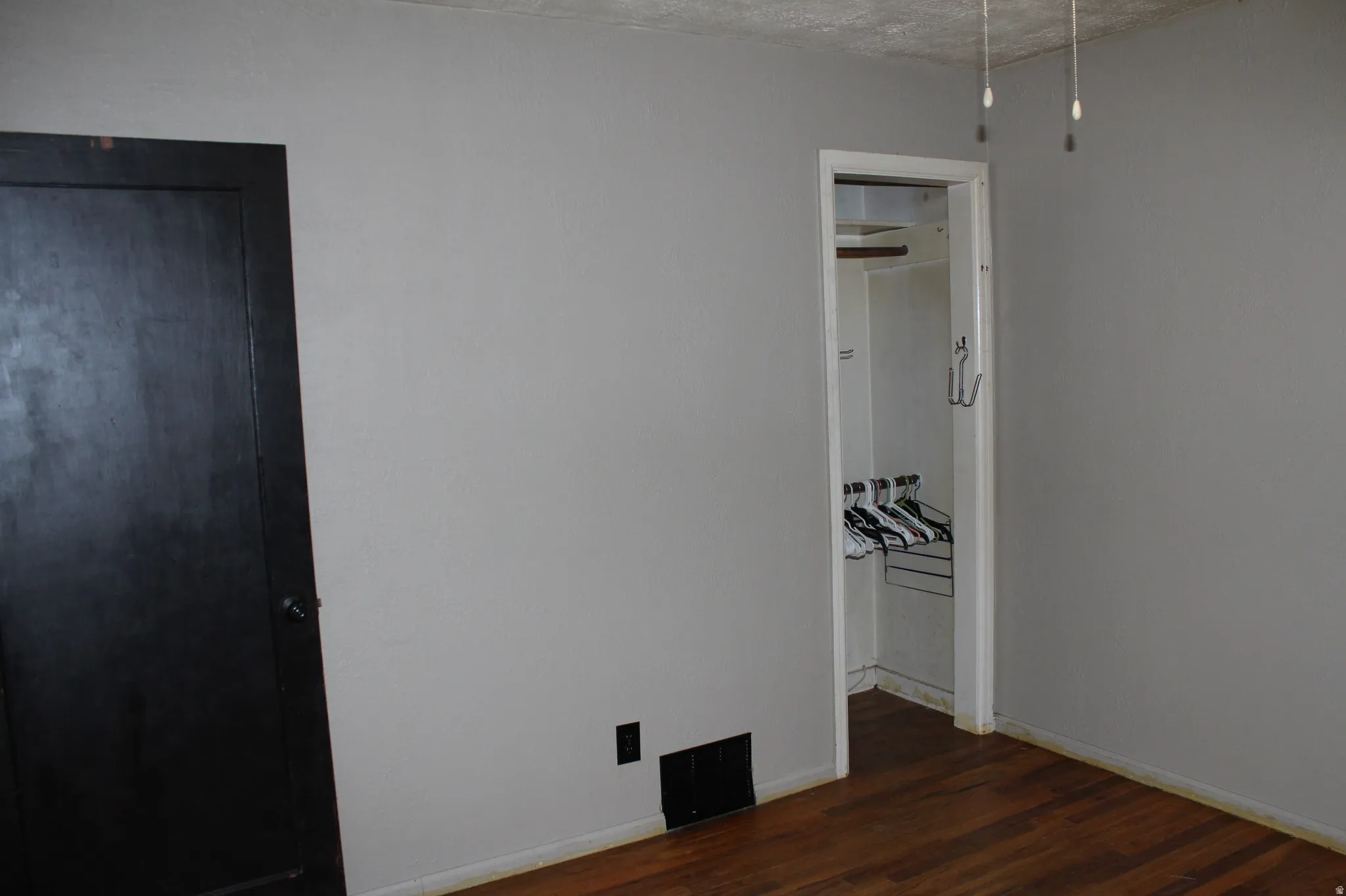 Unfurnished bedroom with dark wood finished floors and baseboards