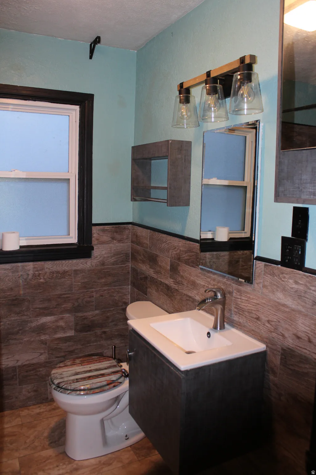 Bathroom featuring vanity, tile walls, and a wainscoted wall