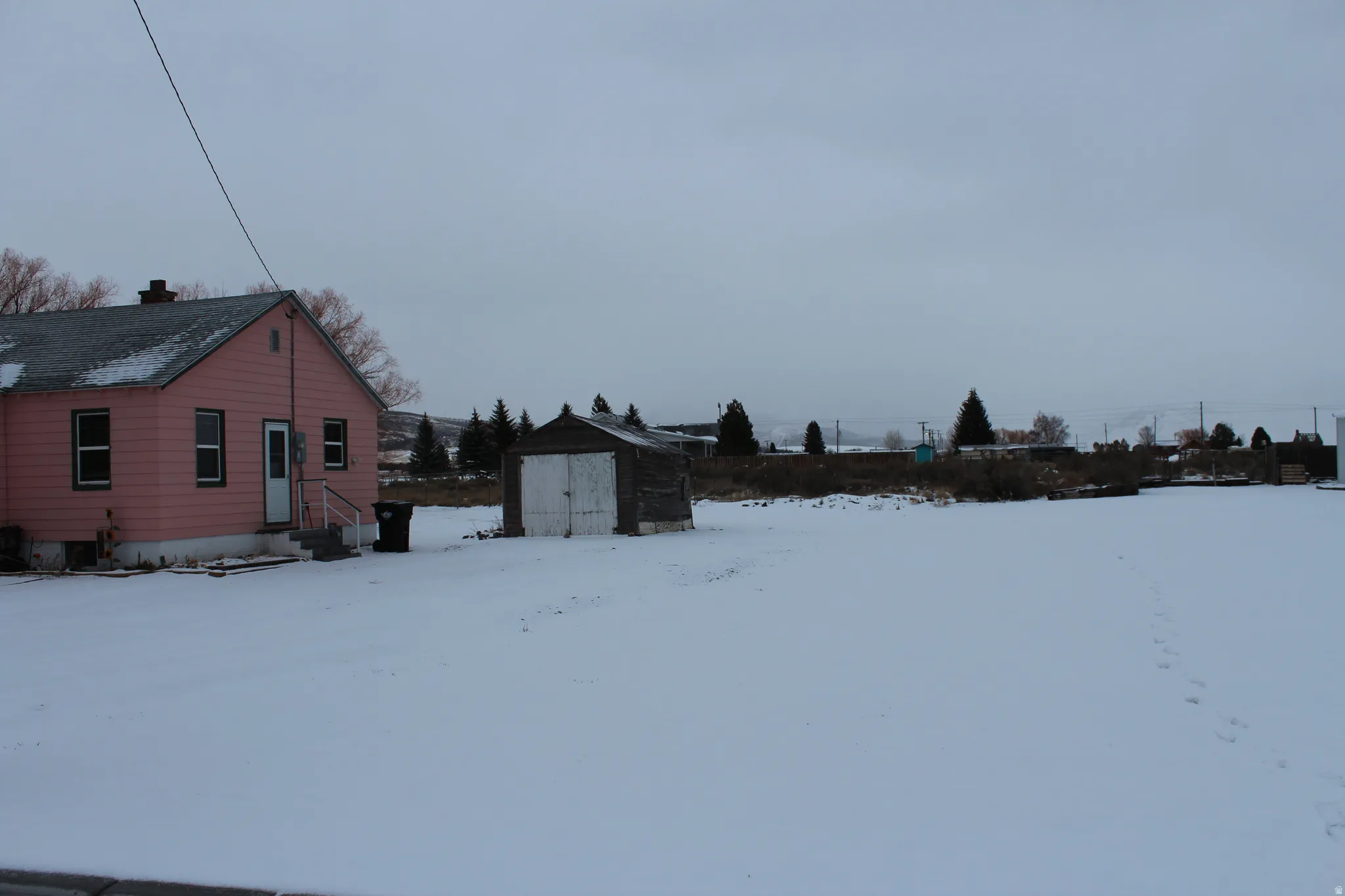 View of snow covered exterior featuring a storage unit
