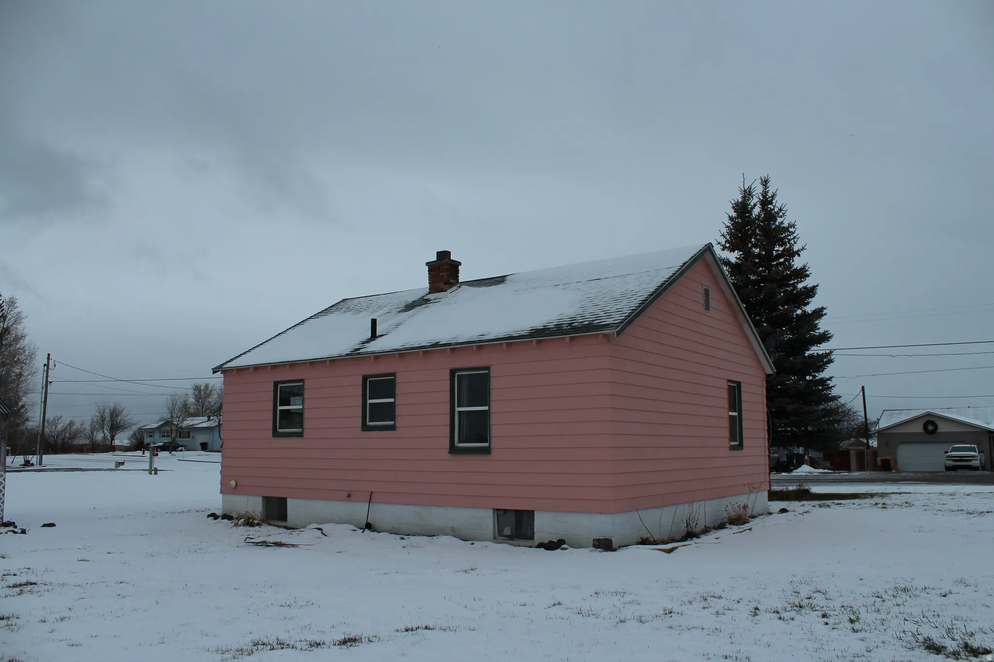 View of snow covered exterior featuring a chimney