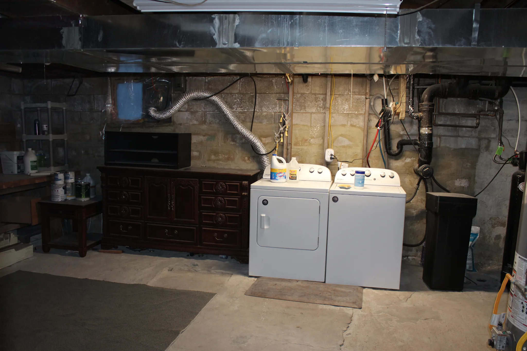 Unfinished basement with washing machine and clothes dryer and water heater