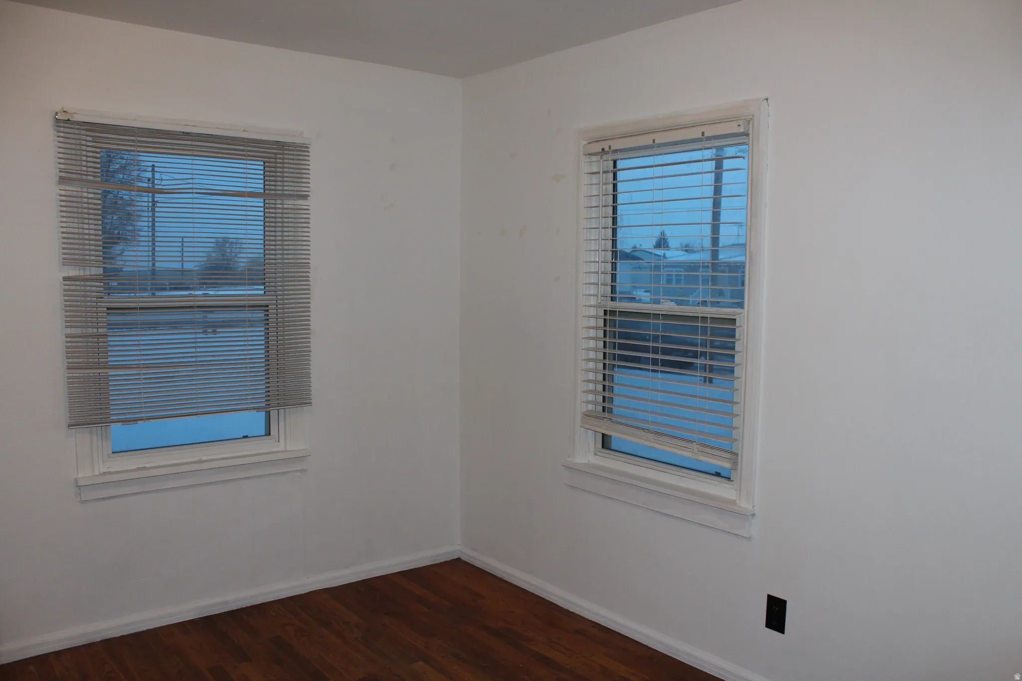Empty room with dark wood finished floors and baseboards