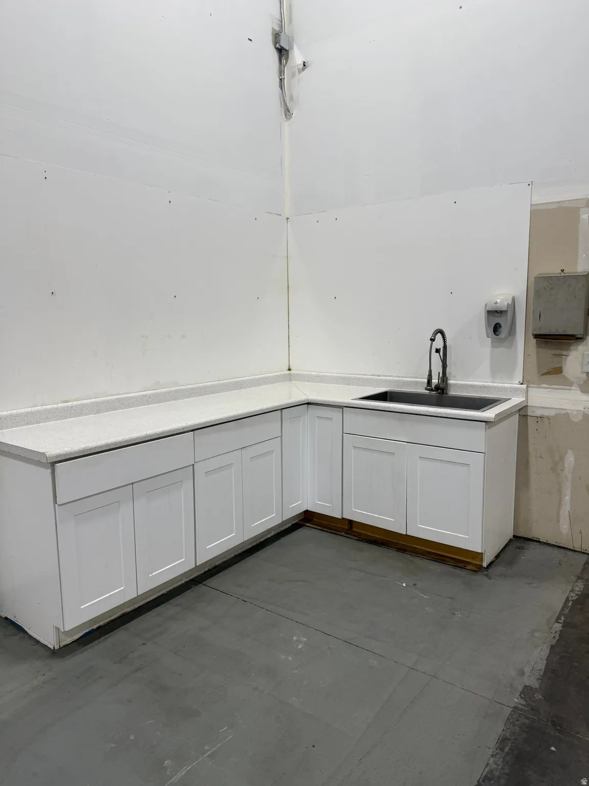 Kitchen featuring white cabinetry and concrete floors
